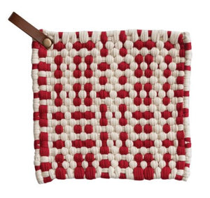 A square woven pot holder, featuring a red and off-white basketweave pattern with a brown leather loop at the top left, shown on a plain white background.