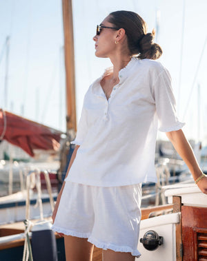 model wearing white cotton ruffled tee and matching traveler ruffle shorts. 
