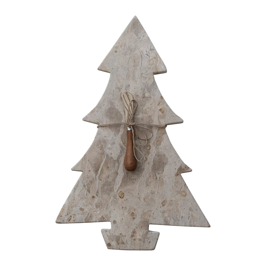 Decorative beige marble Christmas tree serving board with a wooden cheese knife on a white background.