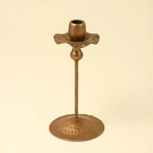Bronze tulip-shaped candle holder on a beige background
