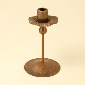 Bronze tulip-shaped candle holder on a beige background