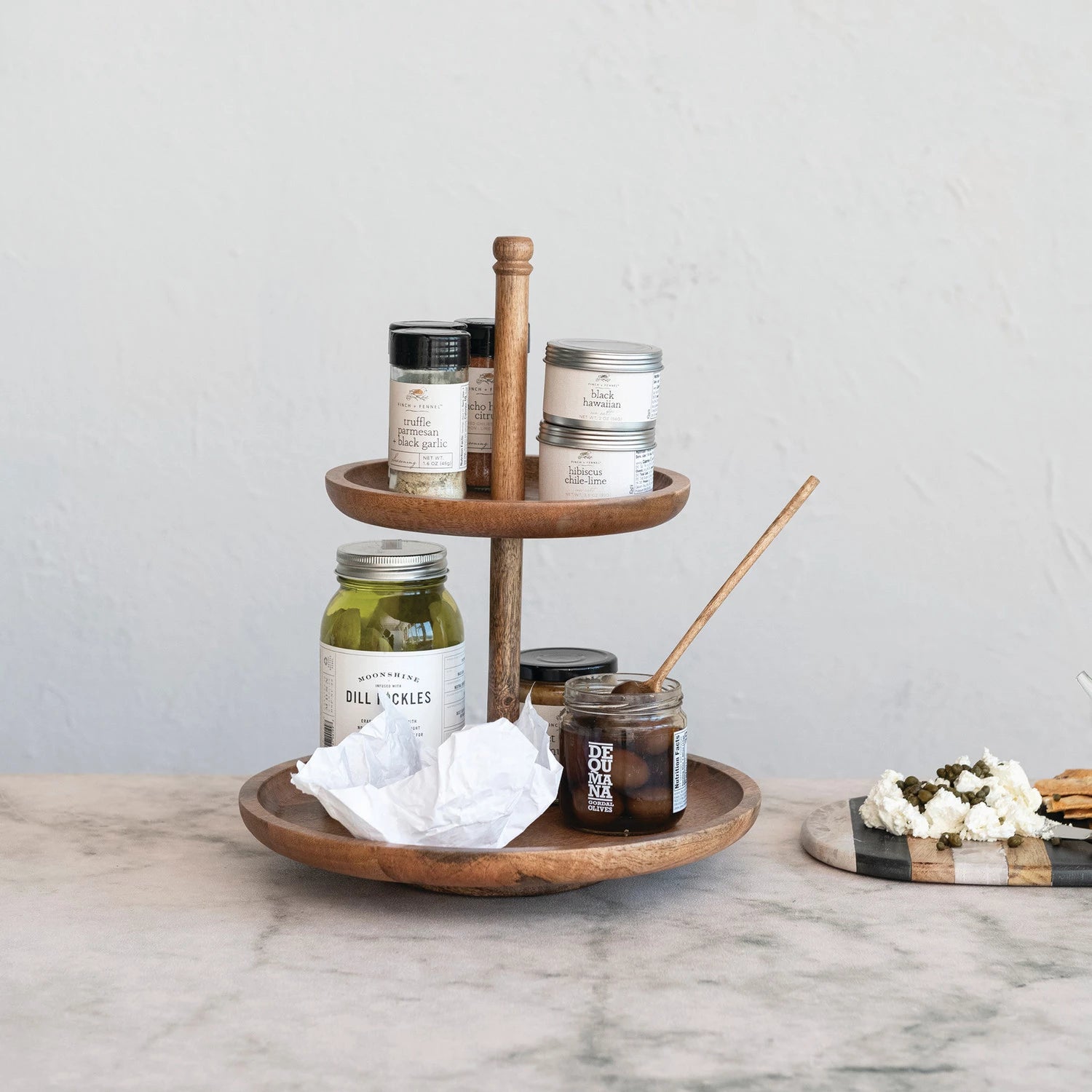 Two tiered mango wood tray with various kitchen cooking ingredients displayed. 