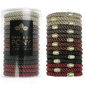 A clear cylindrical container holding multiple braided ponytail hair ties, shown beside a stacked display of the same hair ties. The ponytails come in beige, brown, black, and burgundy, each accented with small metallic gold oval beads.
