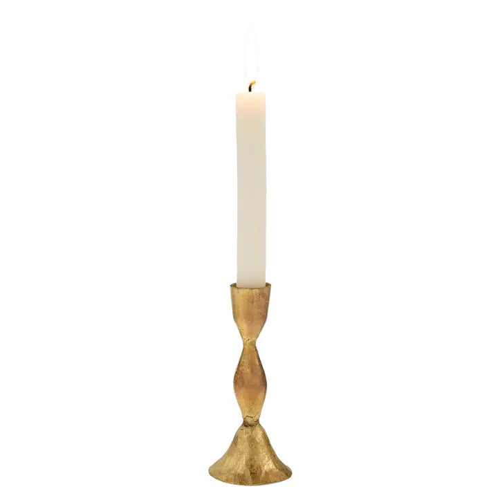 Gold candle holder with a white candle on a white background
